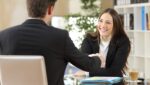 Male real estate broker shaking hands with a female real estate agent he has just recruited